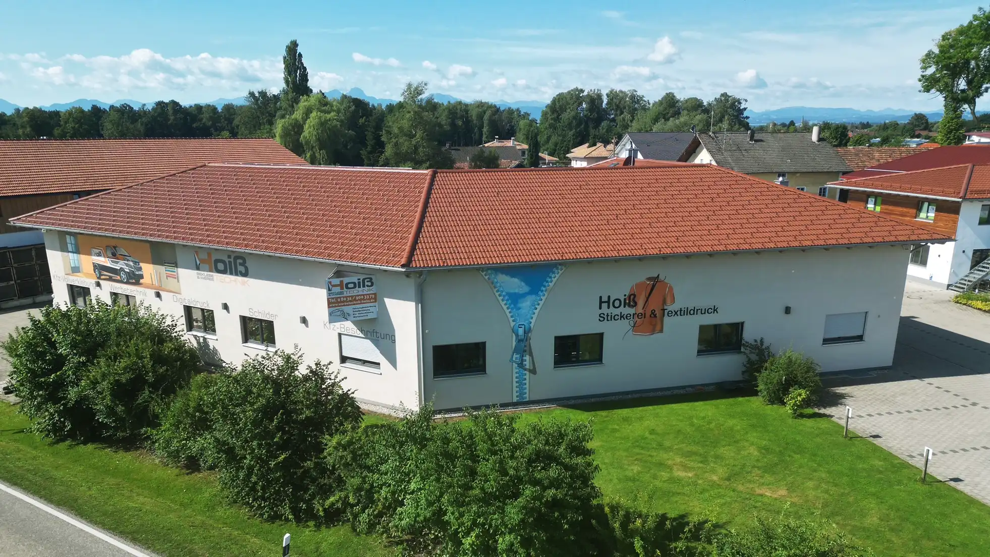 Hoiß Werbetechnik Firmengebäude und Werkstatt in Rosenheim mit moderner Fassade, Unternehmenslogo und professioneller Außendarstellung