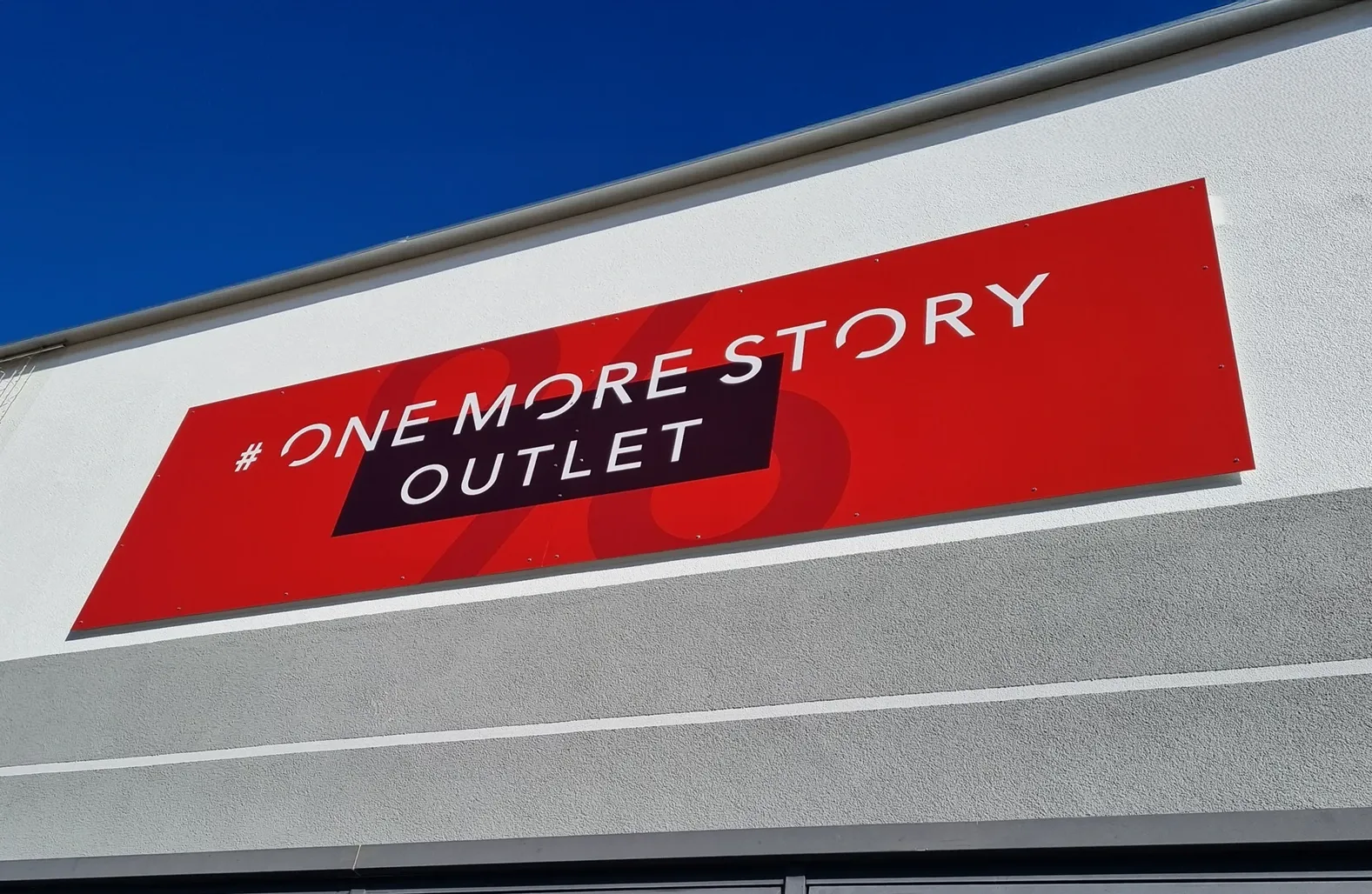 Professionell kaschiertes Aluverbund-Firmenschild an moderner Fassade